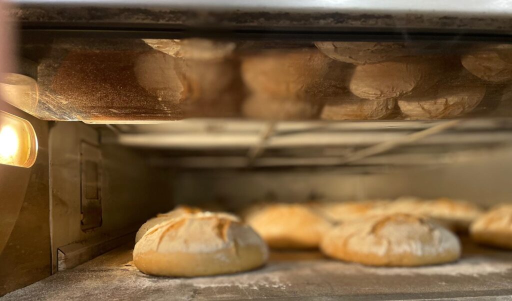 intérieur d'un four de boulangerie dans lequel cuisent des meules de pain artisanales